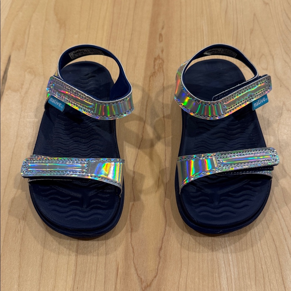 Native Charley Hologram sandals with a navy blue base and iridescent straps C8